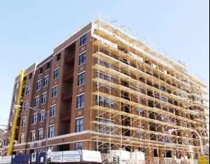 Front view of a multi-story building with scaffolding on one side.