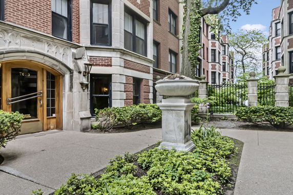 Front view of a multi-story brick apartment building with decorative stone elements.