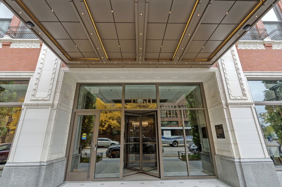 Entrance view of a building with glass doors and an overhang.