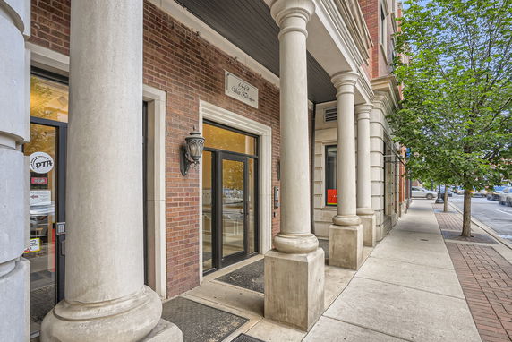 Front view of a building with large columns and brick exterior.