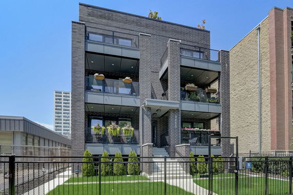 Front view of a multi-story building with balconies and modern design.