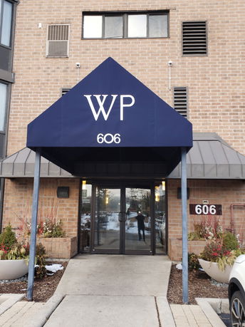 Front view of a building entrance with a blue canopy labeled WP 606.