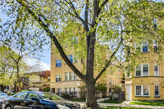 Front view of a multi-story apartment building with brick exterior.