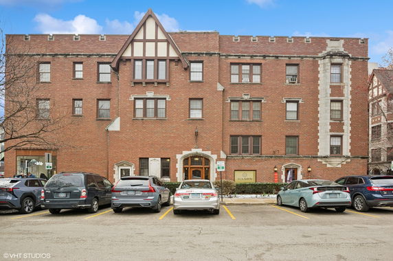 Front view of a multi-story brick building with arched windows.