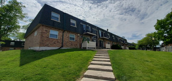 Front view of a two-story apartment building with balconies.