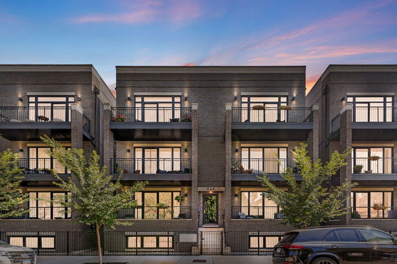 Front view of a multi-story building with balconies and modern design.
