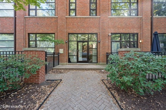 Front view of a brick building with large windows and a central glass entrance.