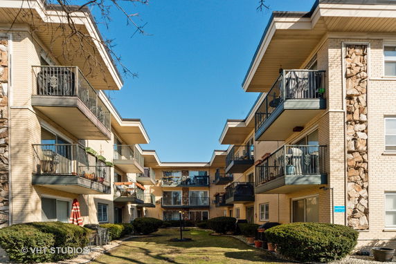 Front view of a multi-story apartment building with balconies.