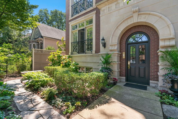 Front view of a house with an arched doorway and large windows.