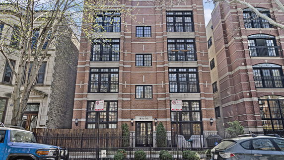 Front view of a multi-story brick building with large windows.