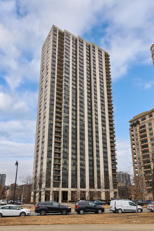 Front view of a high-rise residential building with multiple balconies.