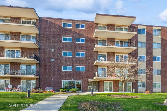 Front view of a multi-story apartment building with balconies.