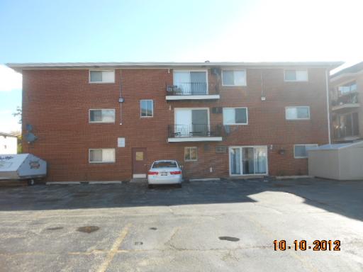 Front view of a three-story brick apartment building.