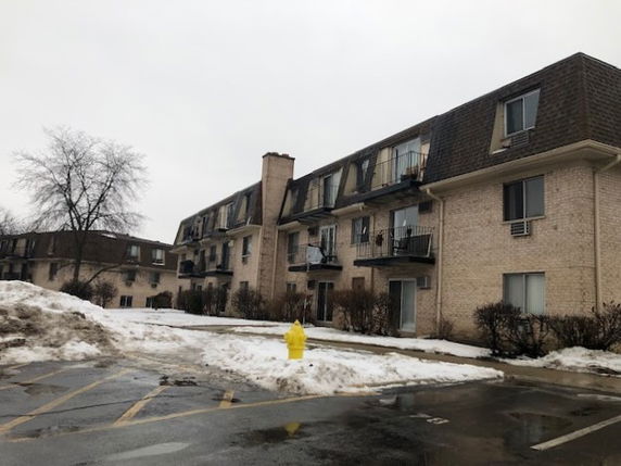 Front view of a three-story residential building with balconies.