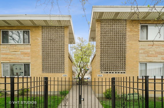 Front view of two mid-century style apartment buildings with decorative brickwork.