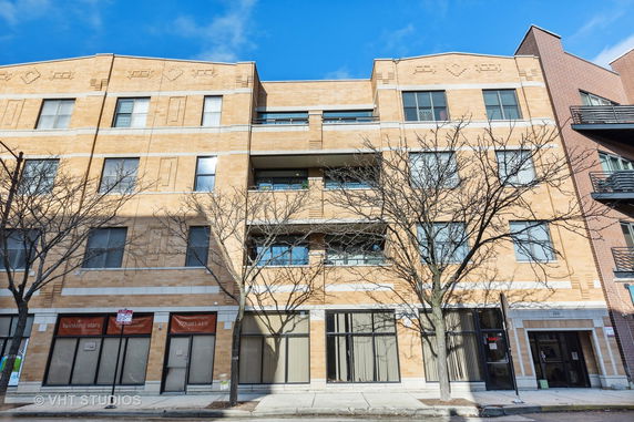 Front view of a multi-story brick building with balconies.
