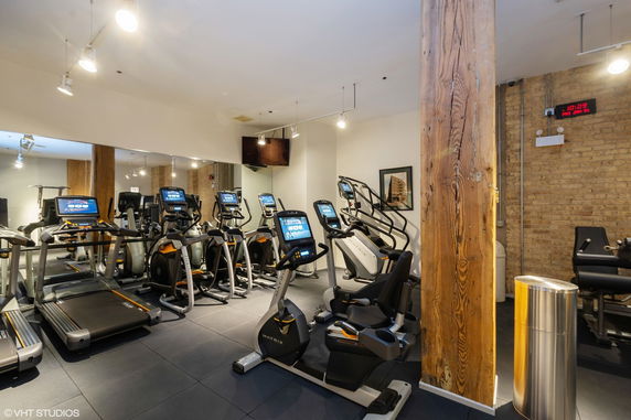 Indoor gym area with exercise equipment and mirrors.