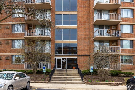 Front view of a multi-story apartment building with balconies.