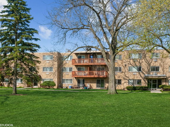 Front view of a three-story apartment building with balconies.