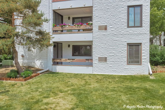Front view of a two-story building with balconies featuring flower pots.