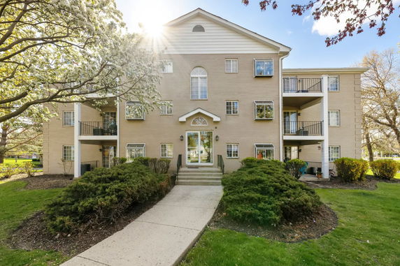 Front view of a three-story apartment building with multiple balconies.
