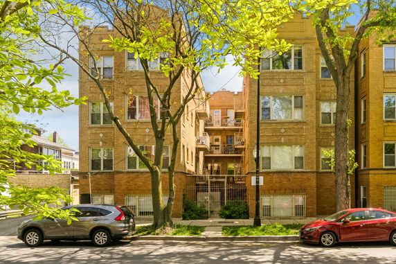 Front view of a multi-story brick apartment building with decorative elements.
