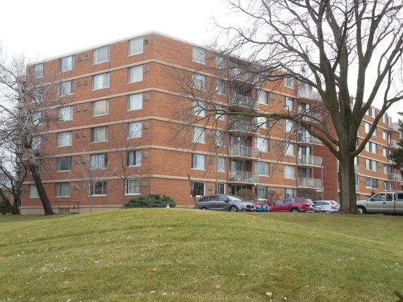 Front view of a multi-story apartment building with balconies.