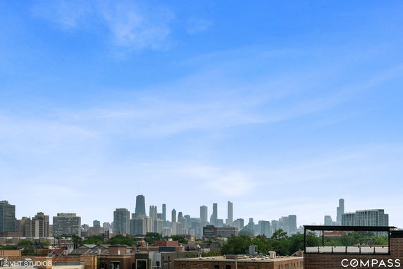 Skyline view with several high-rise buildings in the distance under a clear blue sky.