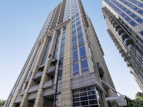 Front view of a tall, modern high-rise building with multiple windows and balconies.