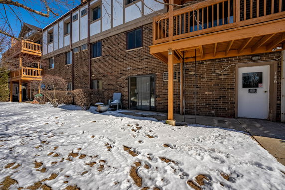 Exterior view of a multi-story building with brick facade and wooden balconies.