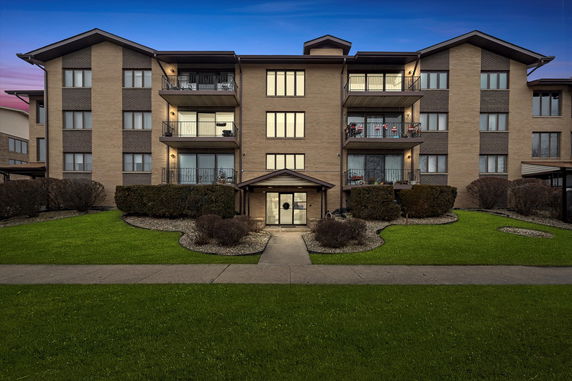 Front view of a multi-story apartment building with balconies.