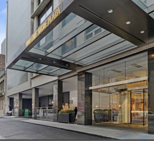 Front view of a building entrance with glass canopy.
