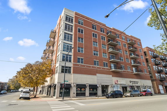 Front view of a multi-story apartment building with balconies.