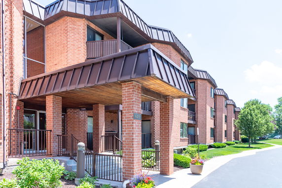 Front view of a multi-story brick residential building with a covered entrance.