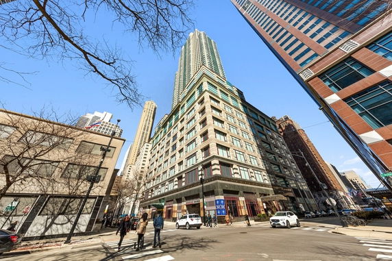 View of a tall multi-story building on a city street corner.