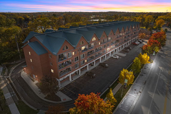Front view of a multi-story brick building with balconies and blue roof.