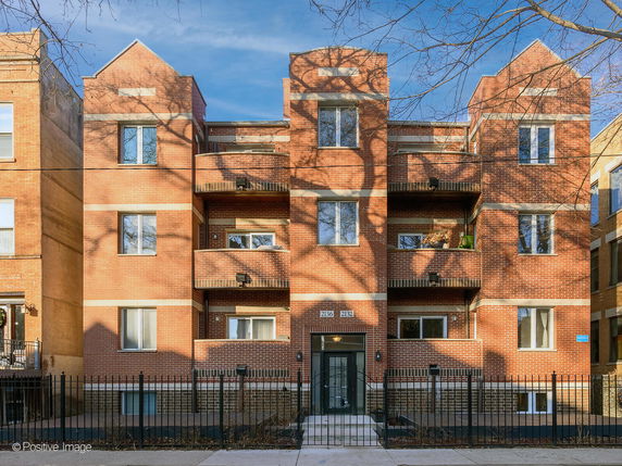 Front view of a multi-story brick building with balconies.