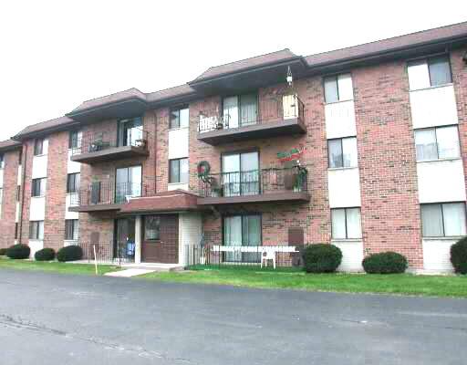 Front view of a three-story apartment building with balconies.