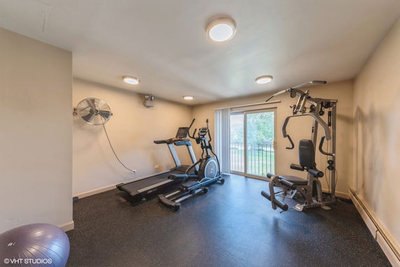 Indoor gym area with exercise equipment and a large window.