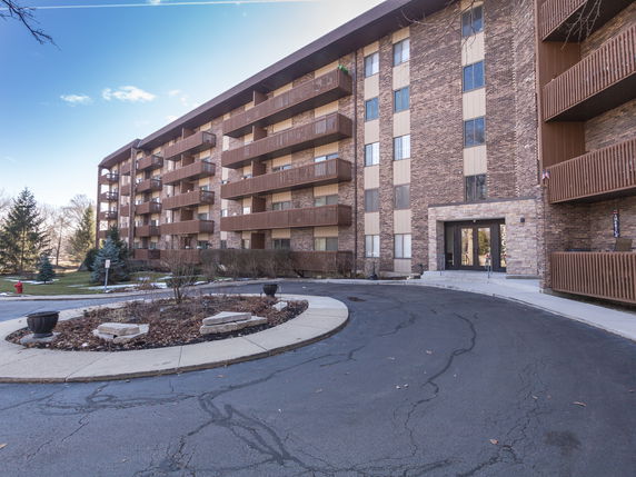 Front view of a multi-story brick building with balconies.