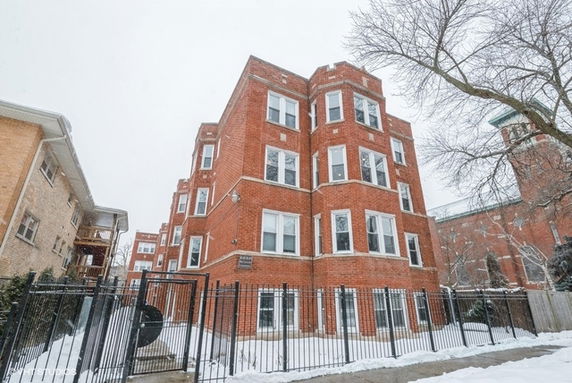 Front view of a multi-story brick apartment building.