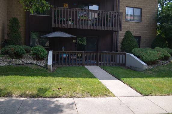Front view of a building with balconies and a walkway leading to the entrance.