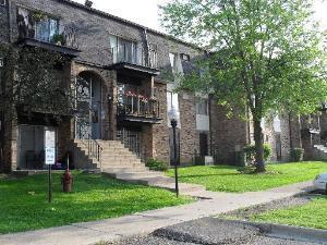 Front view of a multi-story brick apartment building with balconies.