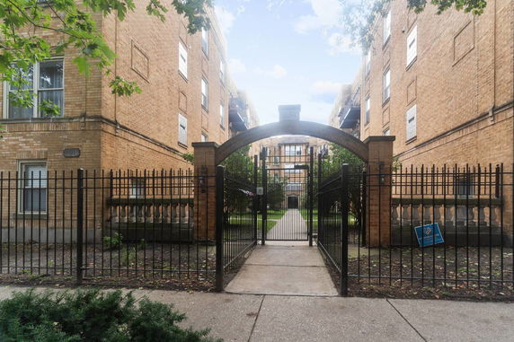 Front view of a residential building with brick facade and gated entrance.