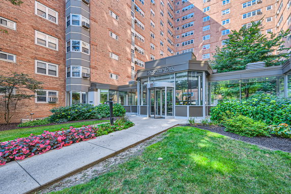 Front view of a high-rise residential building with a glass entrance.