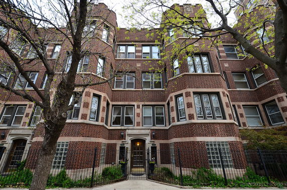 Front view of a multi-story brick building with ornate architectural details.