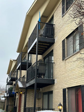 Side view of a multi-story apartment building with balconies.