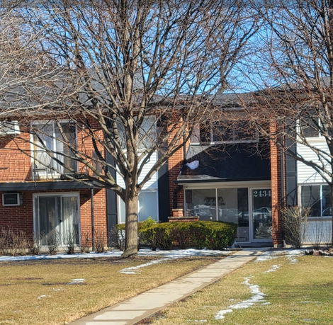 Front view of a two-story residential building with brick and siding exterior.