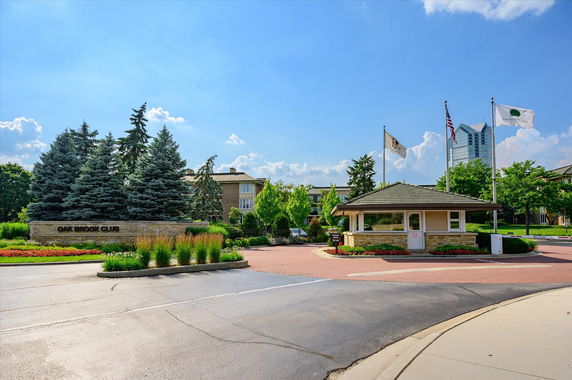 Front view of a building with a guardhouse entrance and flagpoles.