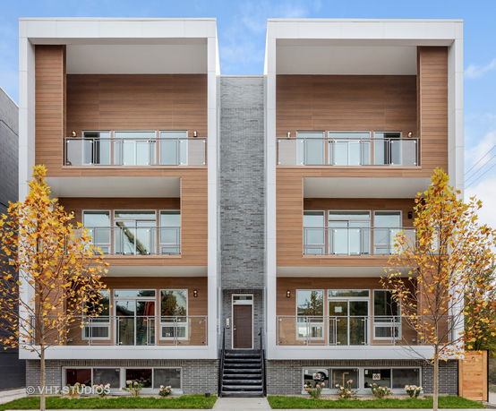 Front view of a modern multi-story residential building with balconies.